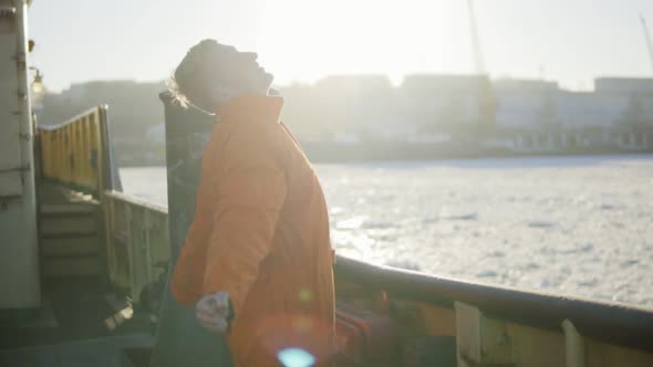 Harbor Worker in Orange Uniform Standing By the Board of the Ship