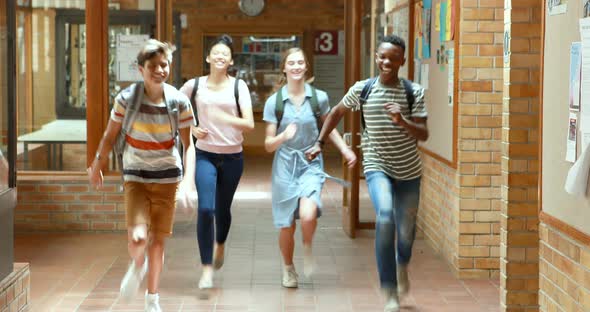 Excited classmates running in corridor