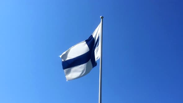 The flag of Finland waving in slow motion with clear blue sky in the background