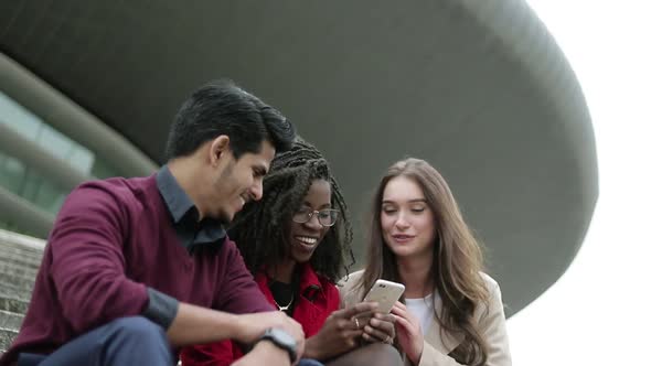 Young People Googling on Phone Place To Go, Discussing