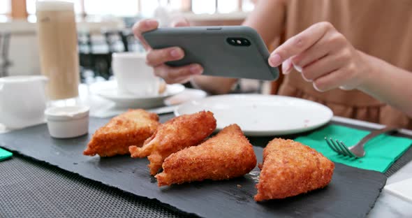 Woman Taking Photo on Her Fried Chicken Wing