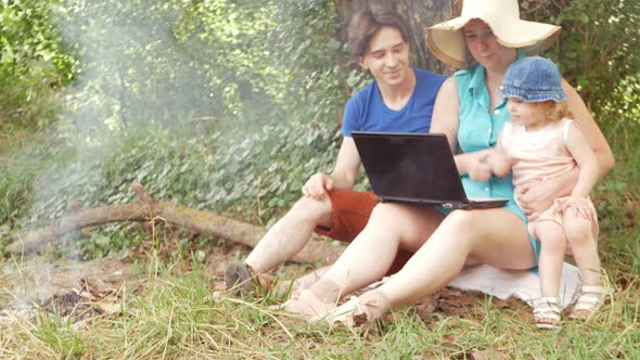 A Family in the Woods Communicates Via Video Link Using a Laptop