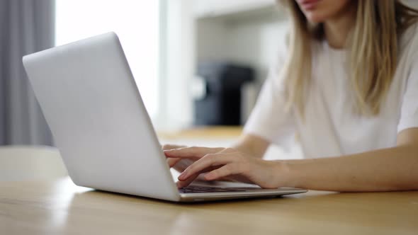 Concentrated Woman Typing on Laptop at Home