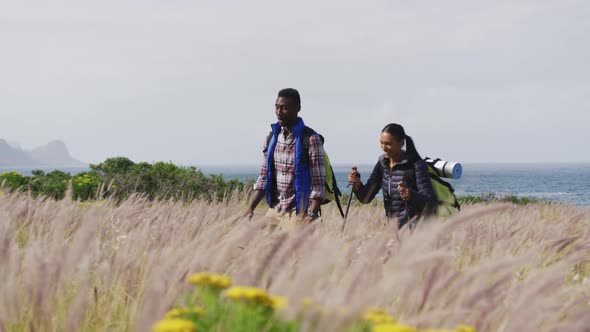 African american couple walking while trekking in the mountains