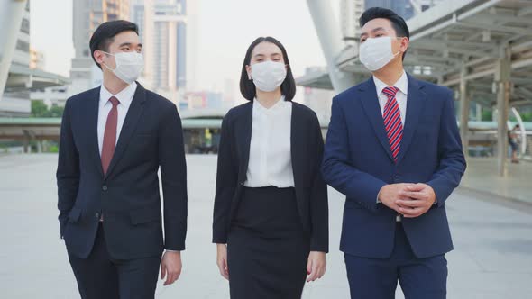 Group of young office businesspeople wear mask, walking outdoor in city with new normal lifestyle.