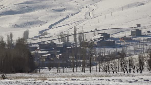 Village Houses on Edge of Snowy Plain and Hill Slope in Winter Siberia Russia