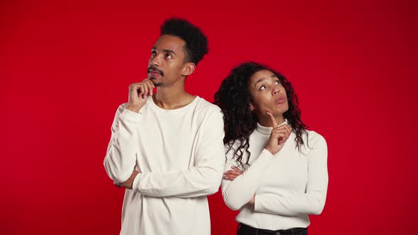 Portrait of Young Thinking Pondering Couple on Red background.Man and Woman