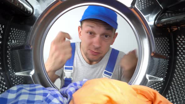 home appliance repairman sticks his head in drum of washing machine and screams