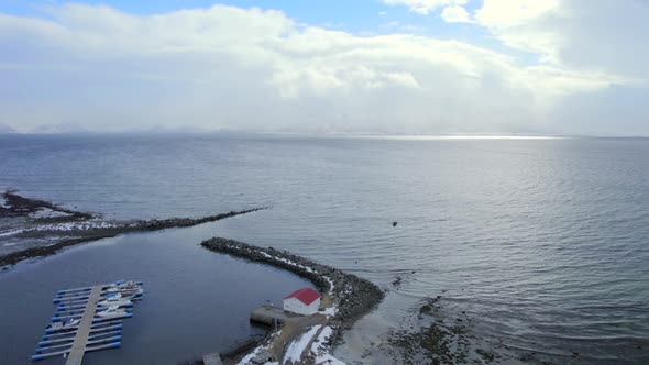 Dolly shot of the Ase Harbor looking out over the ocean with thick clouds and blue sky