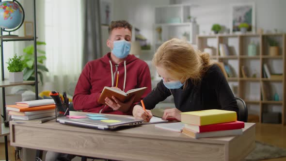 Young Tutor Man is Studying with a Young Woman at Her Home During Quarantine