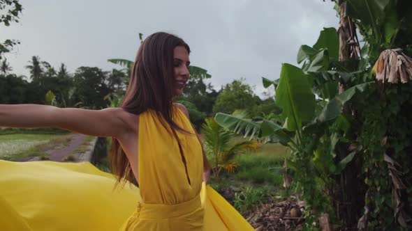 Elegant Lady is Spinning Around on Path of Rice Fields