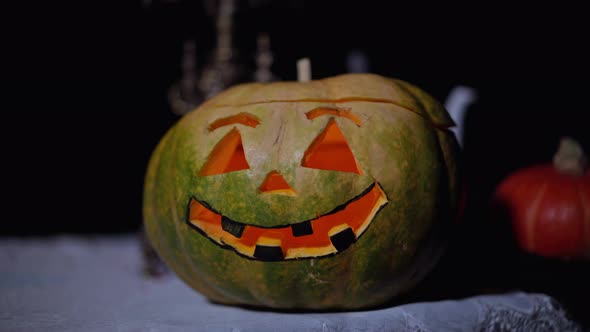 Closeup Halloween Pumpkin on Table in Night Forest with Lightnings Flashing