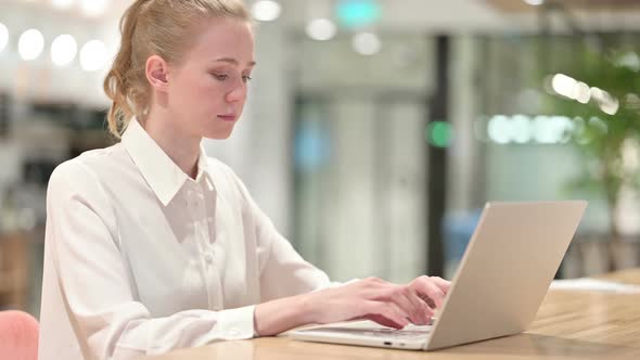 Young Business Woman Typing on Laptop