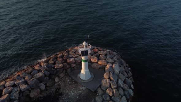 Panorama Drone Shot of a Lighthouse at Golden Hour with Ocean and Sun