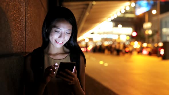 Woman use of mobile phone in city 