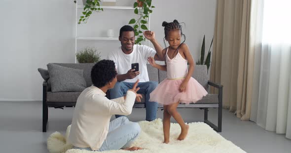 African Family Have Fun at Home Dance to Music Afro Father Uses Mobile Phone Relaxing on Sofa Young