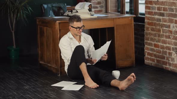 Man Reads Pages on Floor