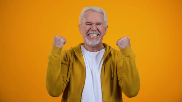 Joyful Male Pensioner Showing Success Gesture and Smiling on Camera Satisfaction