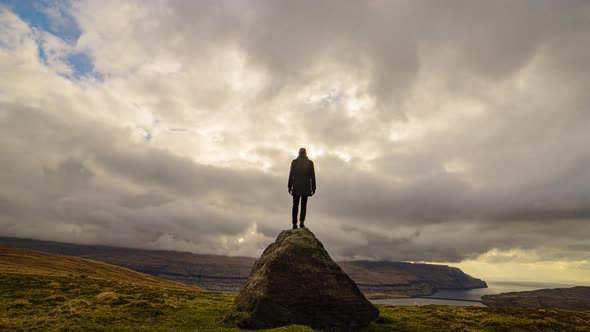 Man Watching Clouds Move Over Dramatic Landscape