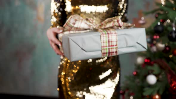 Woman Presents Christmas Gift with Big Bow Decoration