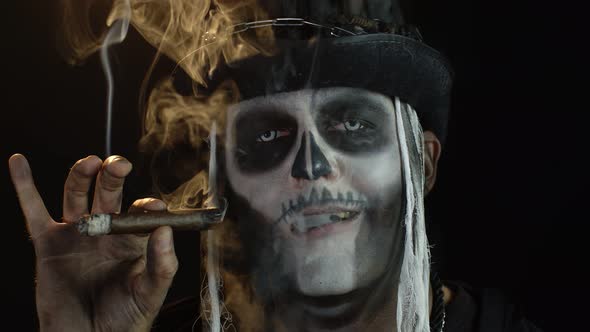 Creepy Man with Skeleton Makeup in Top-hat. Guy Smoking Cigar, Making Faces, Looking at Camera