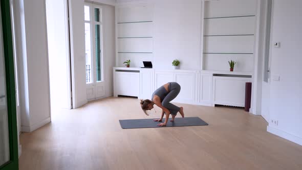 Woman doing yoga on mat in spacious room