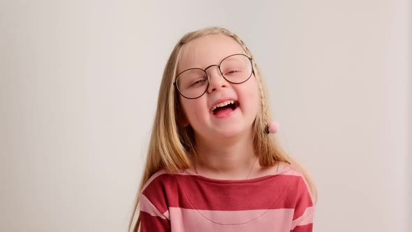 Portrait of a little child cute girl in glasses laughs out loud and smile