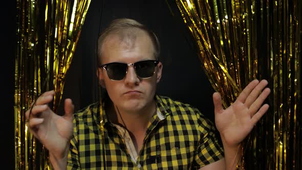 Portrait of Caucasian Man Posing on Black Background. Gold Shining Foil Strips. Party, Music, Disco