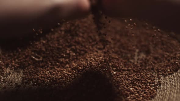 A Male Hands Pick Up a Handful of Buckwheat Grains and Raise Their Palms Up in Slow Motion