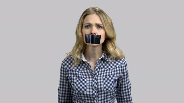 Portrait of Sad Young Woman Can't Speak Because of Her Mouth Taped