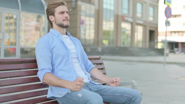 Tense Man Feeling Frustrated While Sitting Outdoor on Bench