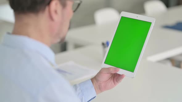 Middle Aged Man Using Tablet with Green Chroma Screen