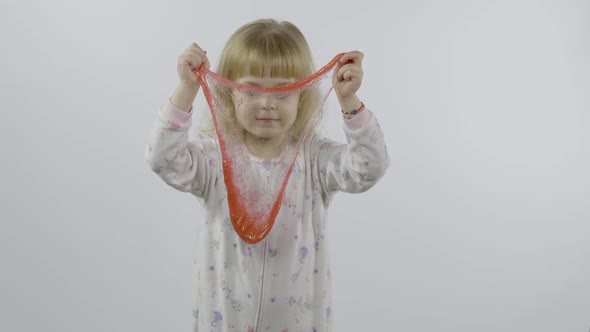 Kid Playing with Hand Made Toy Slime. Child Having Fun Making Red Slime