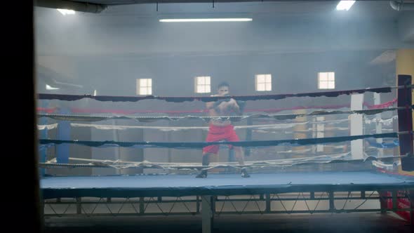 Strong Male Athlete Doing Shadow Fight in Boxing Gym