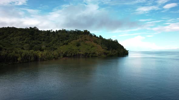 Drone sobre el mar con vista a la montaña y celaje