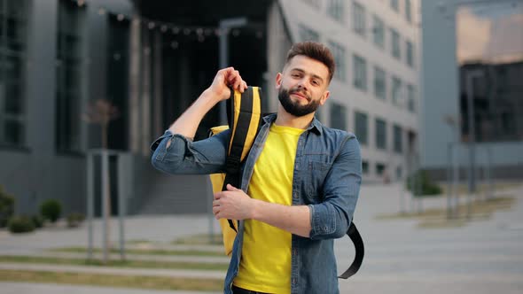 The Food Delivery Guy is Standing and Looking at the Camera