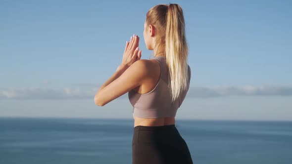 Backside View of Woman Practices Yoga at Morning, Sea on Background, Slow Motion