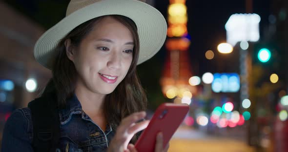 Woman use of mobile phone in Tokyo city at night