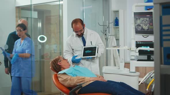 Doctor Showing Xray of Teeth to Patient Using Tablet