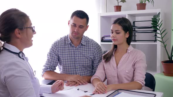 Consultation About Women Health, Married Couple Finds Out From Doctor About Pregnancy in Clinic Room