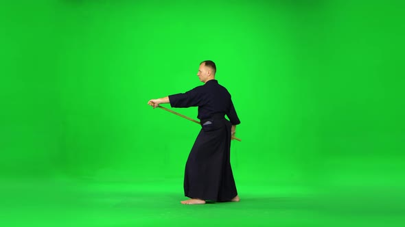 Masculine Kendo Warrior Practicing Martial Art with the Bamboo Bokken on Green Screen.