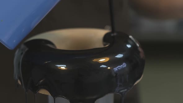 Confectioner Pours Chocolate Topping on Big Baked Doughnut