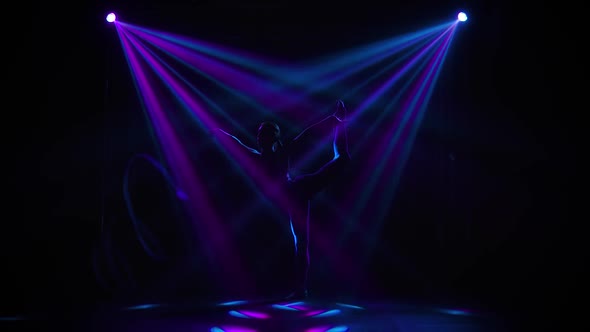 Female Gymnast in Tight Fitting Body Dancing in the Studio with Ribbon. Silhouettes of a Flexible