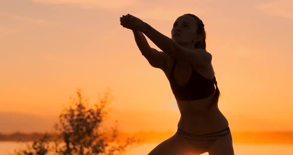 Athletic Girl Playing Beach Volleyball Jumps in the Air and Strikes the Ball Over the Net on a