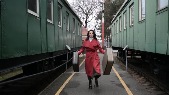 Funny Video a Woman with Suitcases in a Red Coat Is Dancing on the Vintage Railway Platform