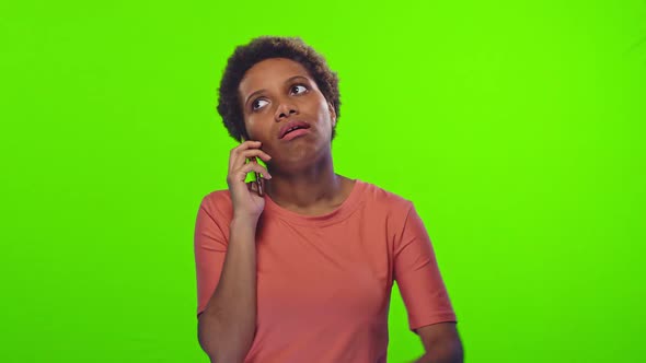 Upset Confused African Woman Holding Cellphone, Annoyed By Spam or Unwanted Call