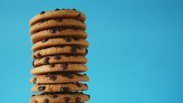 A stack chocolate chip cookies rotate on a blue background.American cookies close up