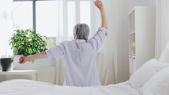 Senior Woman Stretching on Bed at Home Bedroom