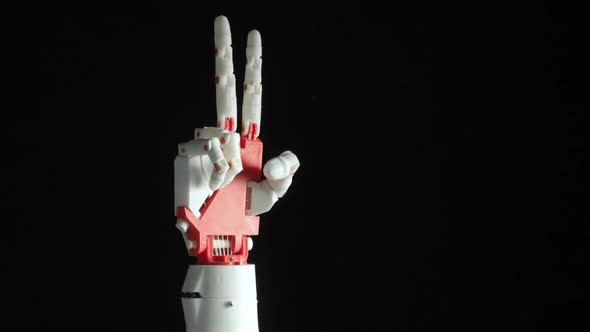 Robotic Programmed Prosthesis Hand Shows Rock Gesture and Victory Sign on Black Background