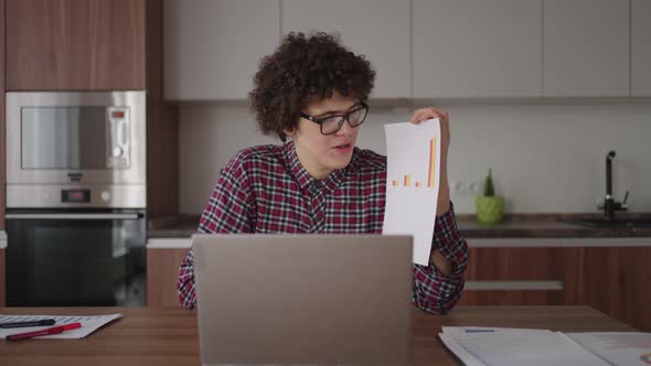 A Man Shows a Graph in a Web Camera